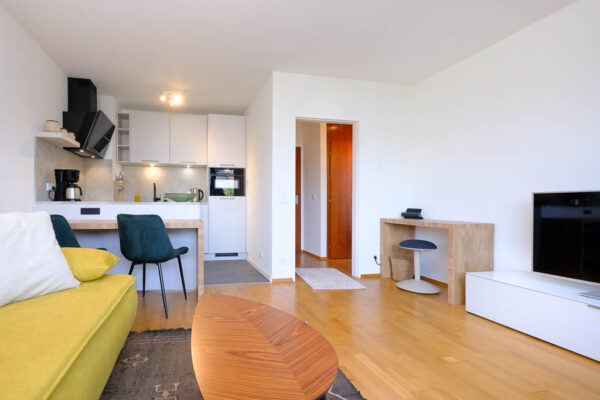 Wohnzimmer Blick auf Schlafsofa, Essbereich, Küche und Arbeitsplatz