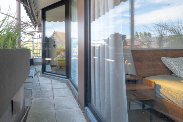Balkon mit Blumenkästen und Sitzmöglichkeit